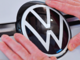 Volkswagen Vorzugsaktie Chart mit aktuellem Kursrücksetzer und Elektroauto-Modellen im Hintergrund, Symbol für die Herausforderungen und Chancen 2026