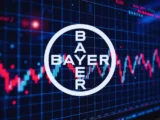 Börsenmonitor mit Bayer Aktienkurs, fallendem Kurschart und DAX-Indikatoren während einer volatilen Marktphase im Hintergrund.