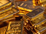 Goldbarren und Goldmünzen vor Finanzcharts mit stark steigendem Goldpreis im europäischen Markt 2026.