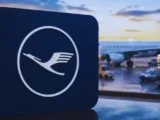 Lufthansa Flugzeug vor modernem Flughafen während die Lufthansa Aktie 2026 im Fokus der Anleger steht.
