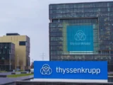 Thyssenkrupp Aktie Chart mit leichtem Plus und Industrieanlage im Hintergrund, Mai 2026