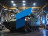 Alt Text für Hauptbild: Rheinmetall-Produktionshalle mit Militärfahrzeugen und Munition