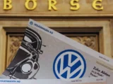 Volkswagen Werk mit modernen Fahrzeugen und fallendem Aktienchart der Volkswagen Vorzugsaktie als Symbol für den Kursrückgang und Marktdruck