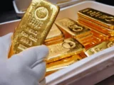 Goldbarren und Goldmünzen als Symbol für die aktuelle Entwicklung des Goldpreises in Deutschland.