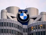 BMW-Aktie und BMW-Fahrzeuge vor der Konzernzentrale in München.