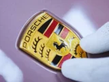 Alt Text Porsche Produktionshalle mit Sportwagen und fallendem