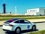 Elon Musk vor Tesla- und SpaceX-Logos mit Börsenchart – Spekulationen über eine mögliche Fusion.